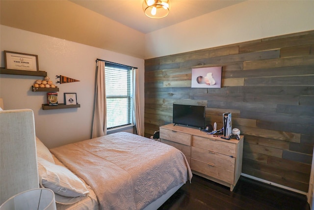 bedroom with wood walls and dark wood-style floors