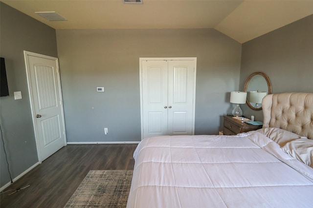 bedroom featuring a closet, baseboards, dark wood finished floors, lofted ceiling, and visible vents