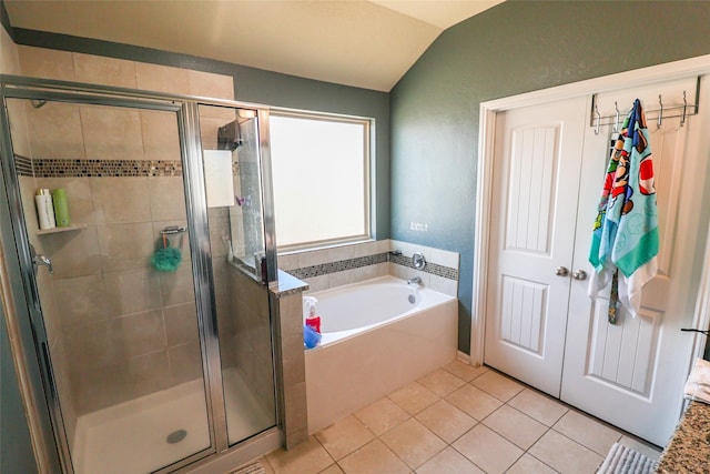 bathroom featuring a bath, tile patterned flooring, a shower stall, and lofted ceiling