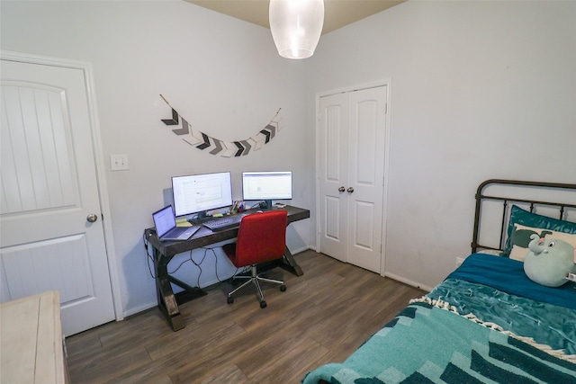 bedroom featuring wood finished floors, a closet, and baseboards