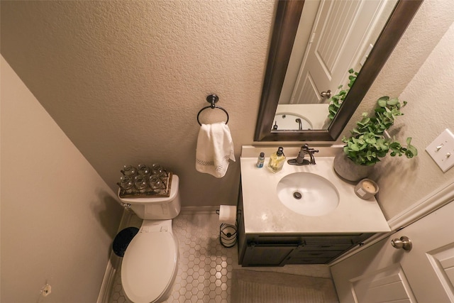 bathroom with baseboards, vanity, and toilet