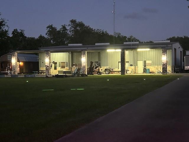 back of house at night with a yard