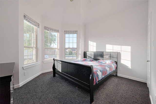 bedroom with carpet floors, baseboards, multiple windows, and lofted ceiling