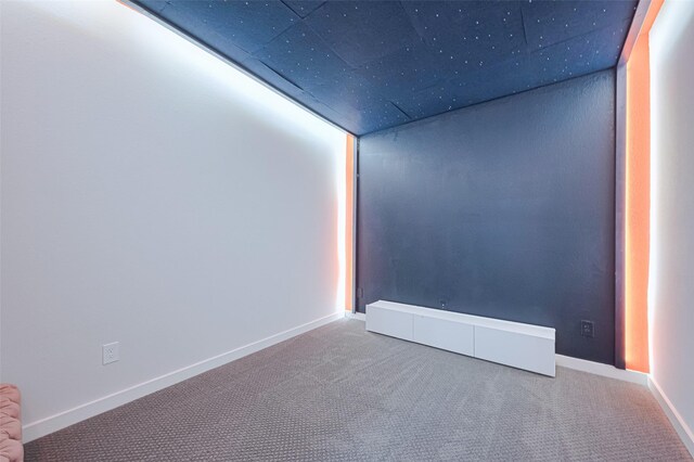 carpeted spare room featuring a baseboard radiator and baseboards