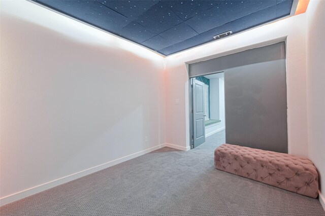 spare room with baseboards and carpet floors