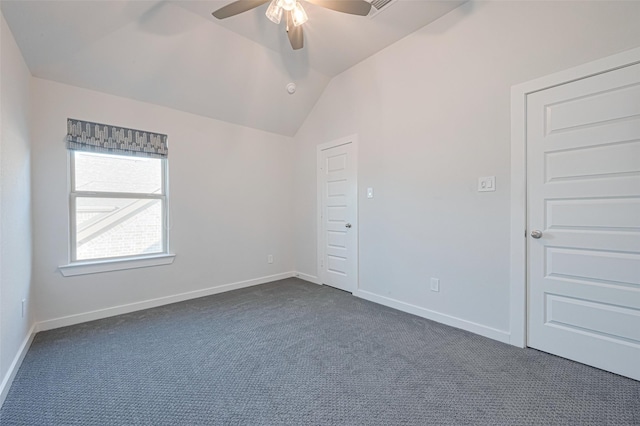 empty room featuring baseboards, dark carpet, a ceiling fan, and lofted ceiling