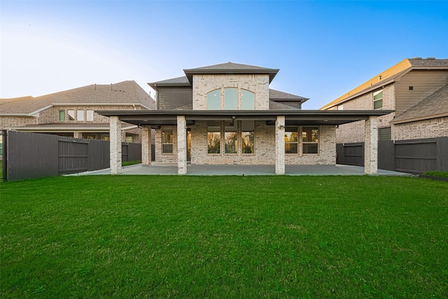 back of property featuring a patio area, a yard, and a fenced backyard