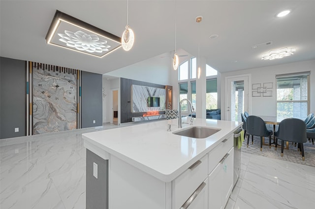 kitchen with visible vents, a sink, open floor plan, stainless steel dishwasher, and marble finish floor