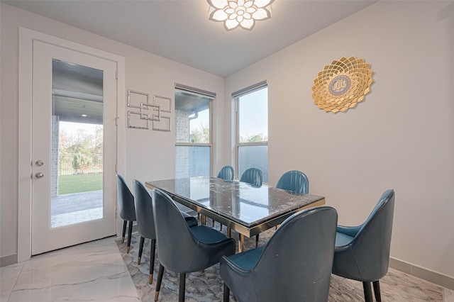 dining area featuring baseboards and marble finish floor