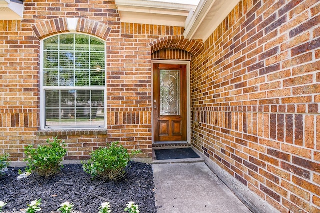 doorway to property featuring brick siding