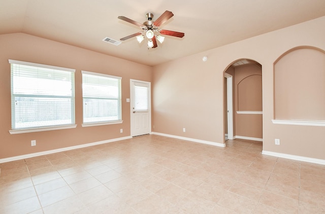 unfurnished room featuring arched walkways, a ceiling fan, light tile patterned flooring, and visible vents