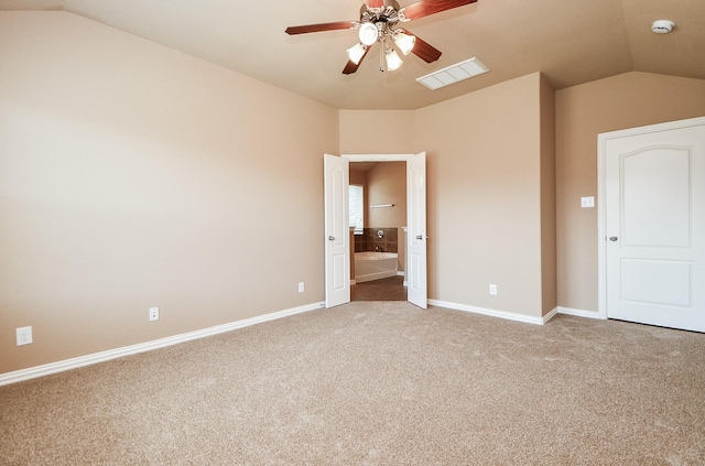 unfurnished bedroom with carpet, vaulted ceiling, visible vents, baseboards, and ensuite bathroom