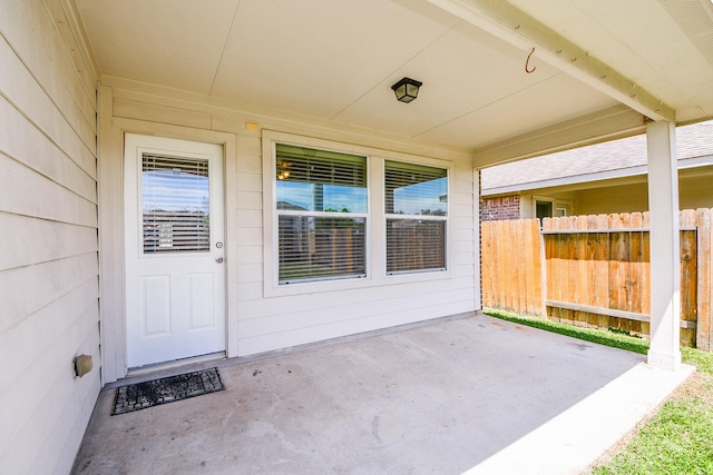 entrance to property with fence and a patio