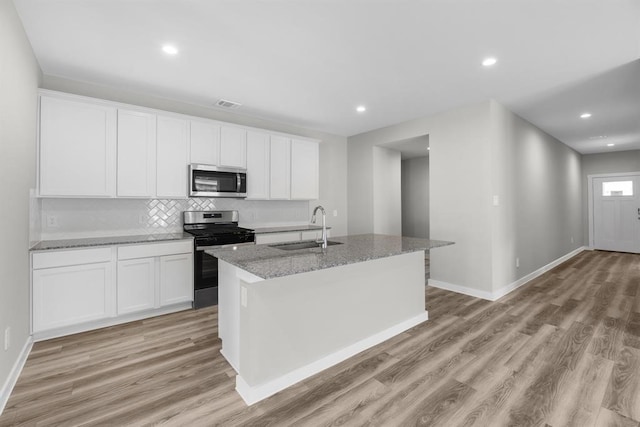 kitchen featuring light wood-type flooring, appliances with stainless steel finishes, a sink, and visible vents