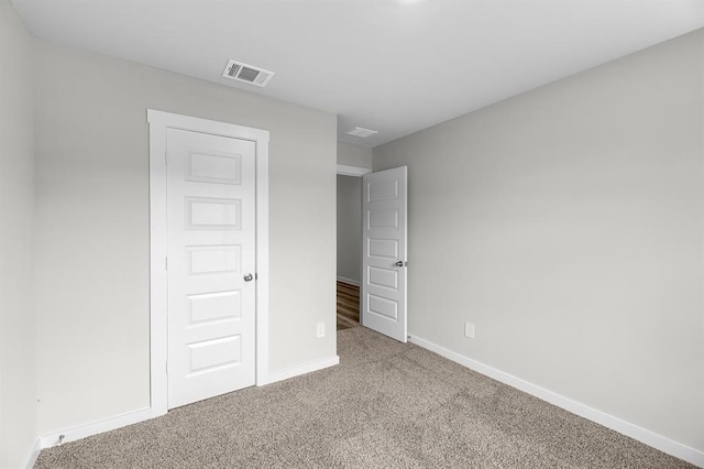 unfurnished bedroom with visible vents, baseboards, and carpet floors