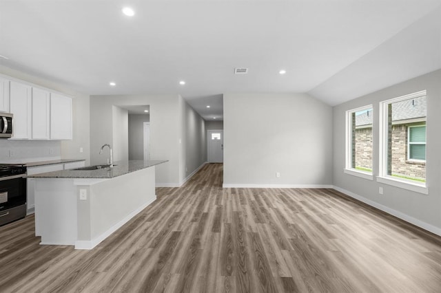 kitchen featuring stainless steel microwave, white cabinets, visible vents, stove, and a sink