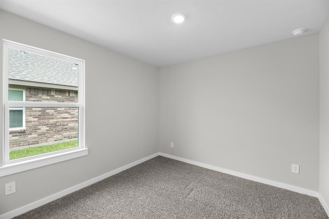 carpeted spare room featuring baseboards