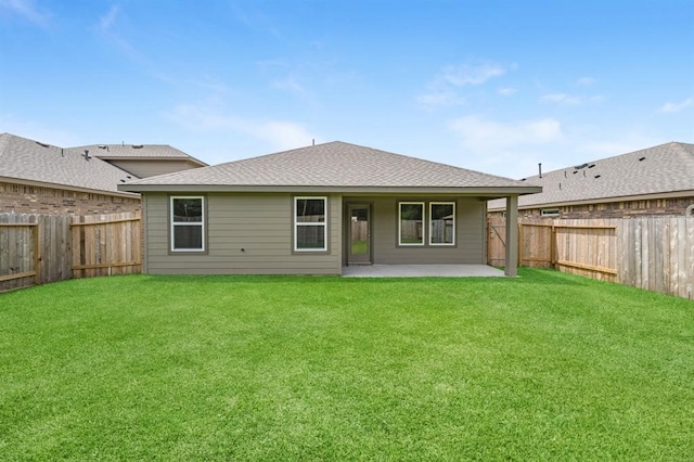 rear view of house featuring a patio area, a shingled roof, a fenced backyard, and a lawn