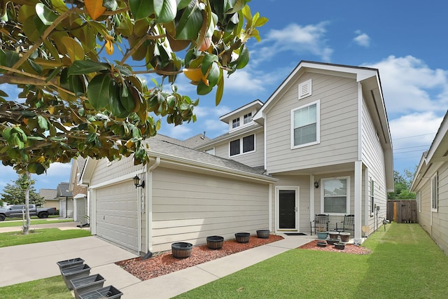 back of house with concrete driveway, an attached garage, a shingled roof, fence, and a lawn