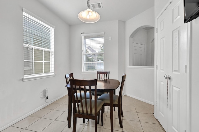 dining space with visible vents, baseboards, arched walkways, and light tile patterned flooring