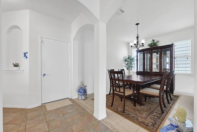 dining room with baseboards, arched walkways, a notable chandelier, and visible vents