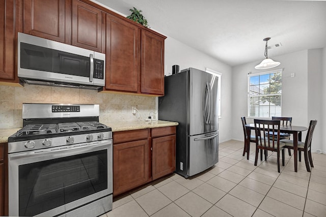 kitchen featuring pendant lighting, light tile patterned floors, stainless steel appliances, baseboards, and backsplash