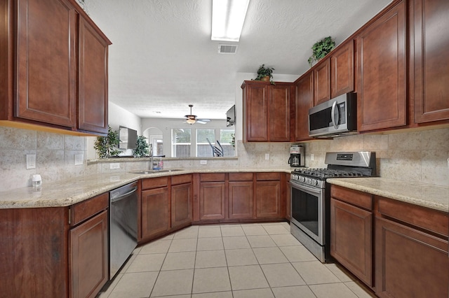 kitchen featuring tasteful backsplash, visible vents, light tile patterned floors, a sink, and stainless steel appliances