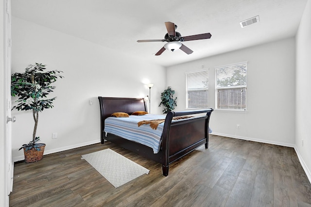 bedroom featuring visible vents, baseboards, ceiling fan, and wood finished floors