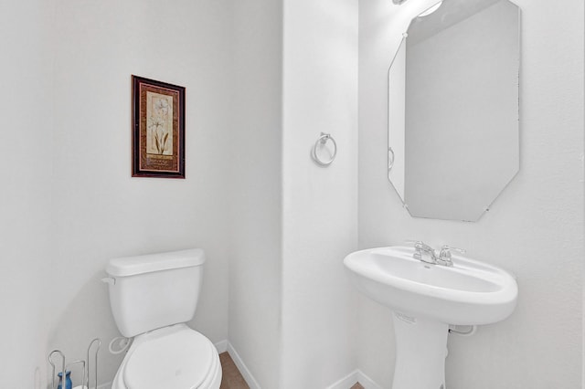 bathroom with baseboards and toilet