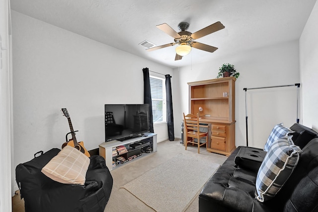 living area with visible vents, ceiling fan, light colored carpet, and baseboards
