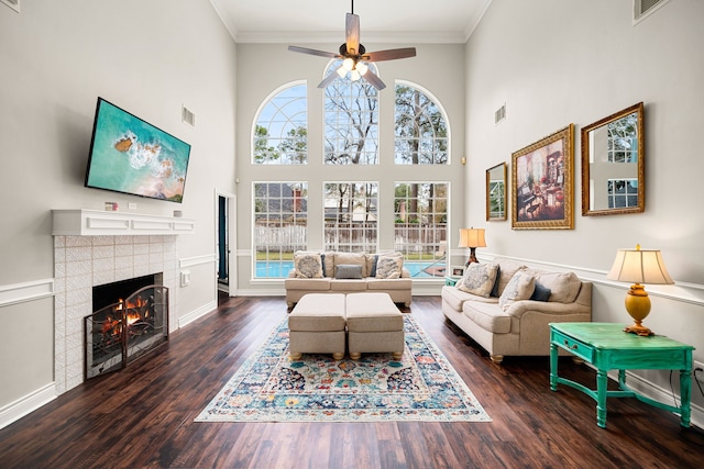 14102 Haynes Dr, Houston, TX 77069 - living area with ornamental molding, a ceiling fan, visible vents, a tile fireplace, and wood finished floors