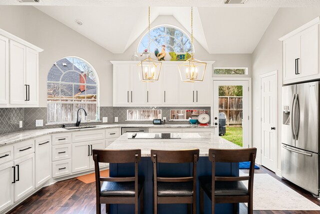 14102 Haynes Dr, Houston, TX 77069 - kitchen with vaulted ceiling, stainless steel refrigerator with ice dispenser, dark wood-type flooring, a kitchen bar, and a sink
