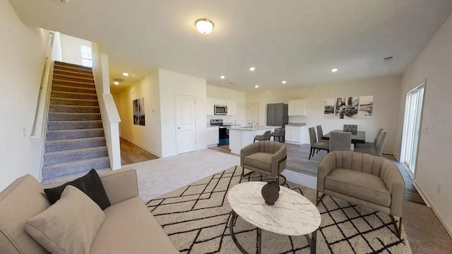 9317 Boulder Blvd, Conroe, TX 77303 - living area with baseboards, recessed lighting, light carpet, and stairs