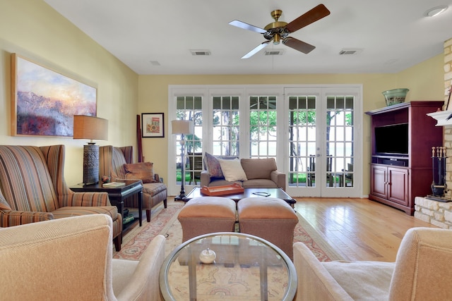 living area featuring light wood-type flooring, french doors, a ceiling fan, and visible vents