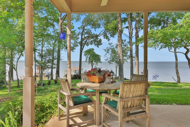 view of patio with a water view and outdoor dining area