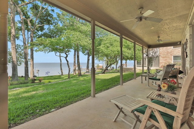 view of patio with a water view and a ceiling fan