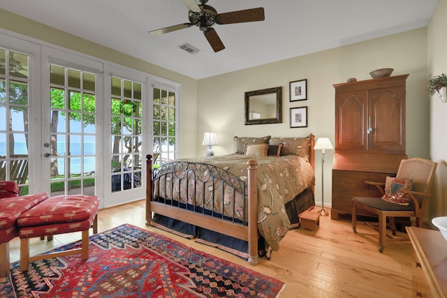 bedroom featuring french doors, visible vents, light wood-style flooring, and access to exterior