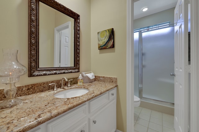 bathroom with a shower stall, tile patterned floors, vanity, and toilet
