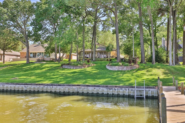 view of dock with a lawn and a water view