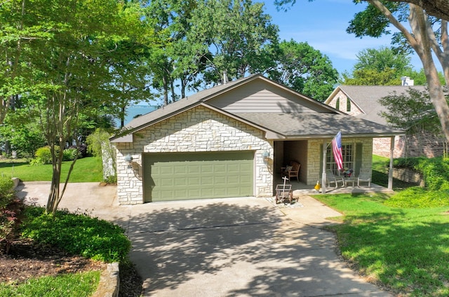view of front of house with a front yard, stone siding, a garage, driveway, and roof with shingles