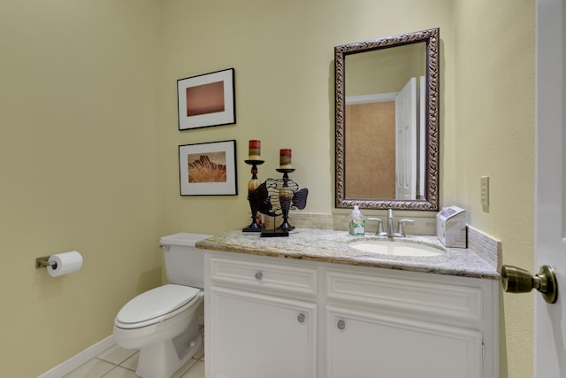 bathroom with tile patterned flooring, vanity, baseboards, and toilet