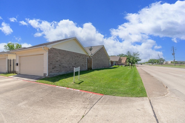 view of home's exterior with a garage, a yard, and brick siding