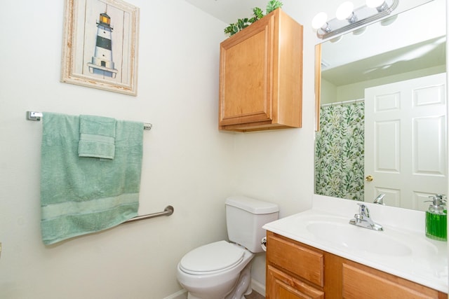 full bathroom with toilet, vanity, and baseboards