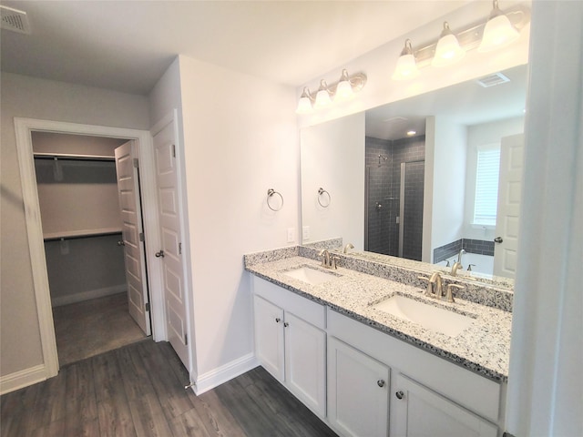 bathroom with a spacious closet, visible vents, a sink, and a stall shower