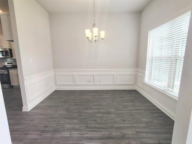 7 Greystone Ct, Angleton, TX 77515 - unfurnished dining area with a chandelier, healthy amount of natural light, dark wood-style floors, and a wainscoted wall
