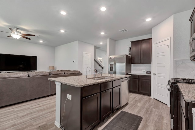 21723 Sarasota Spice St, Tomball, TX 77377 - kitchen featuring ceiling fan, dark brown cabinets, appliances with stainless steel finishes, a sink, and light wood finished floors