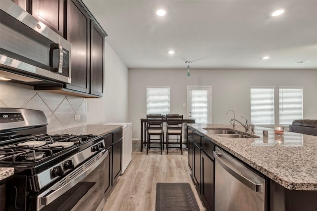 21723 Sarasota Spice St, Tomball, TX 77377 - kitchen with a sink, appliances with stainless steel finishes, recessed lighting, light stone countertops, and decorative backsplash