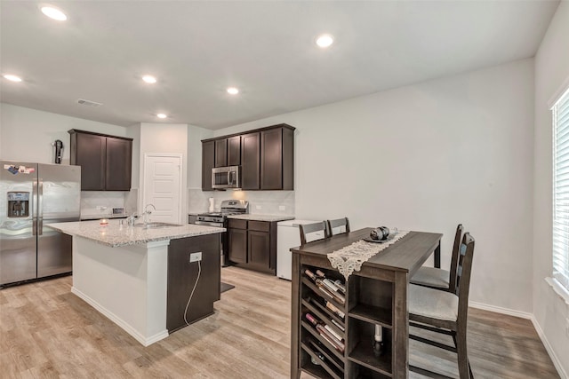 21723 Sarasota Spice St, Tomball, TX 77377 - kitchen featuring appliances with stainless steel finishes, decorative backsplash, a sink, and dark brown cabinetry