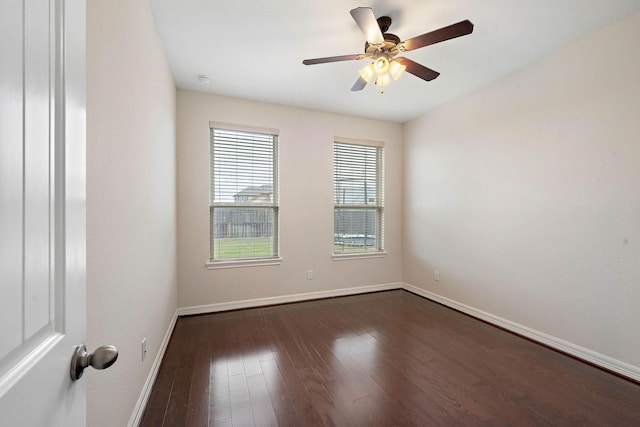 empty room with baseboards, a ceiling fan, and dark wood-style floors