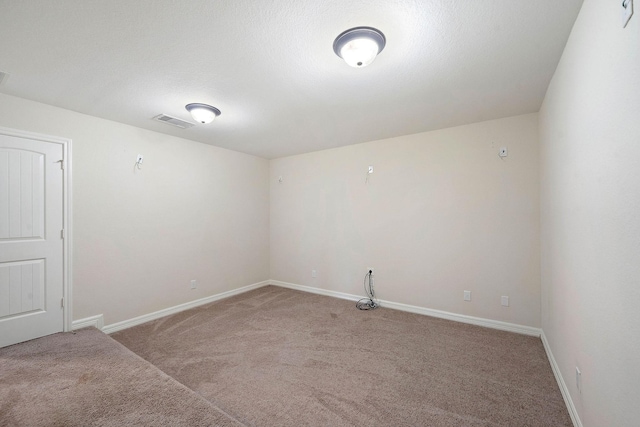 spare room featuring baseboards, visible vents, and carpet floors